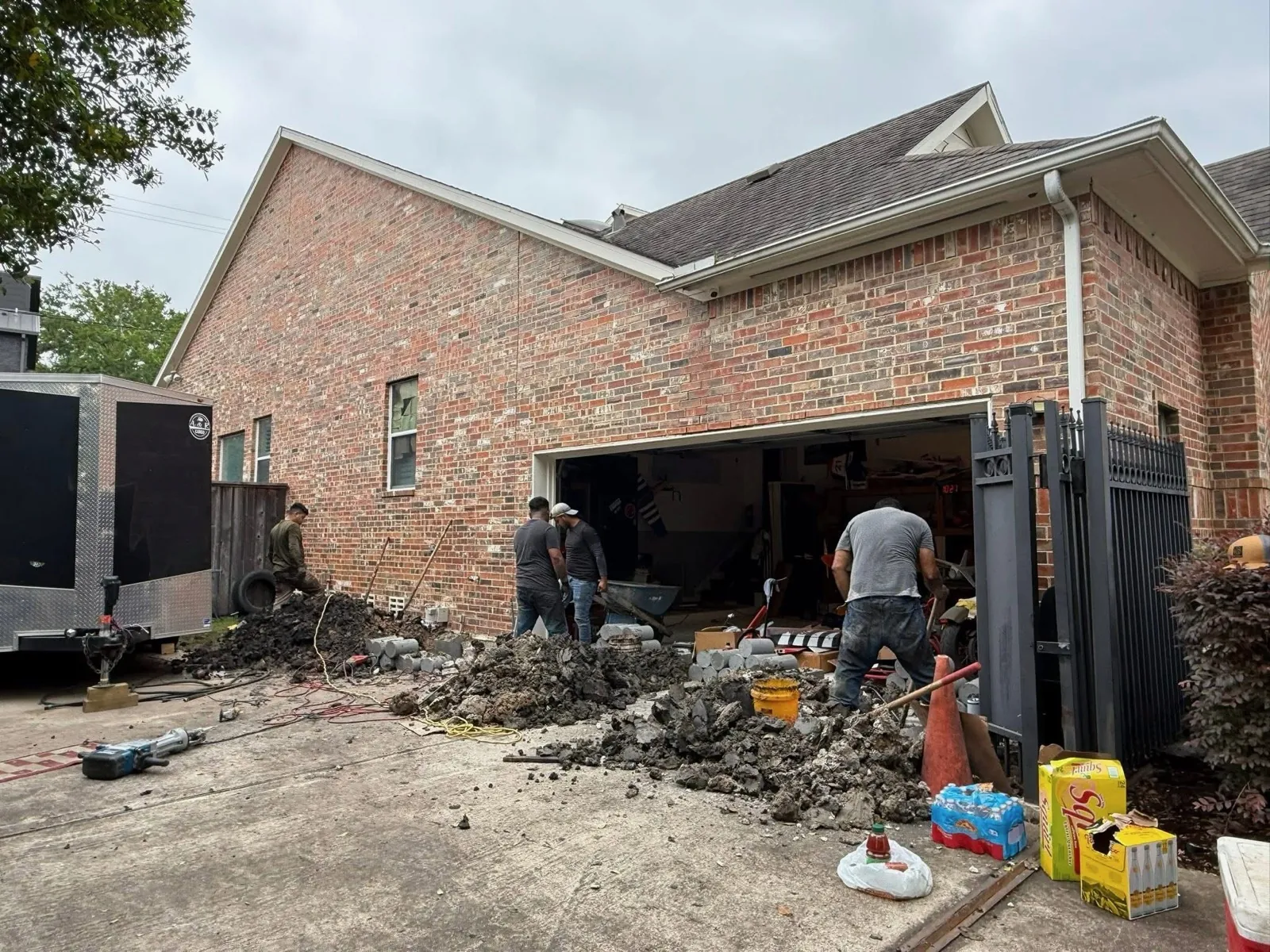 Foundation crew working beside a brick home during a repair project