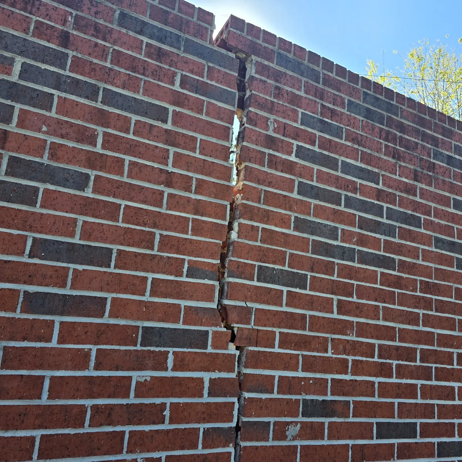 Severe vertical crack running through a brick wall
